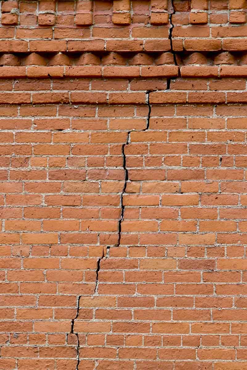 A Brick wall with a crack in it