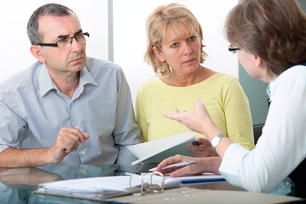 A married couple speaking with an insurance adjuster